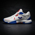 Side profile of the Tenxu All-Rounder cricket rubber shoes in white, blue, and red, featuring a supportive high ankle collar, patterned rubber outsole, and North Legacy Edition branding.