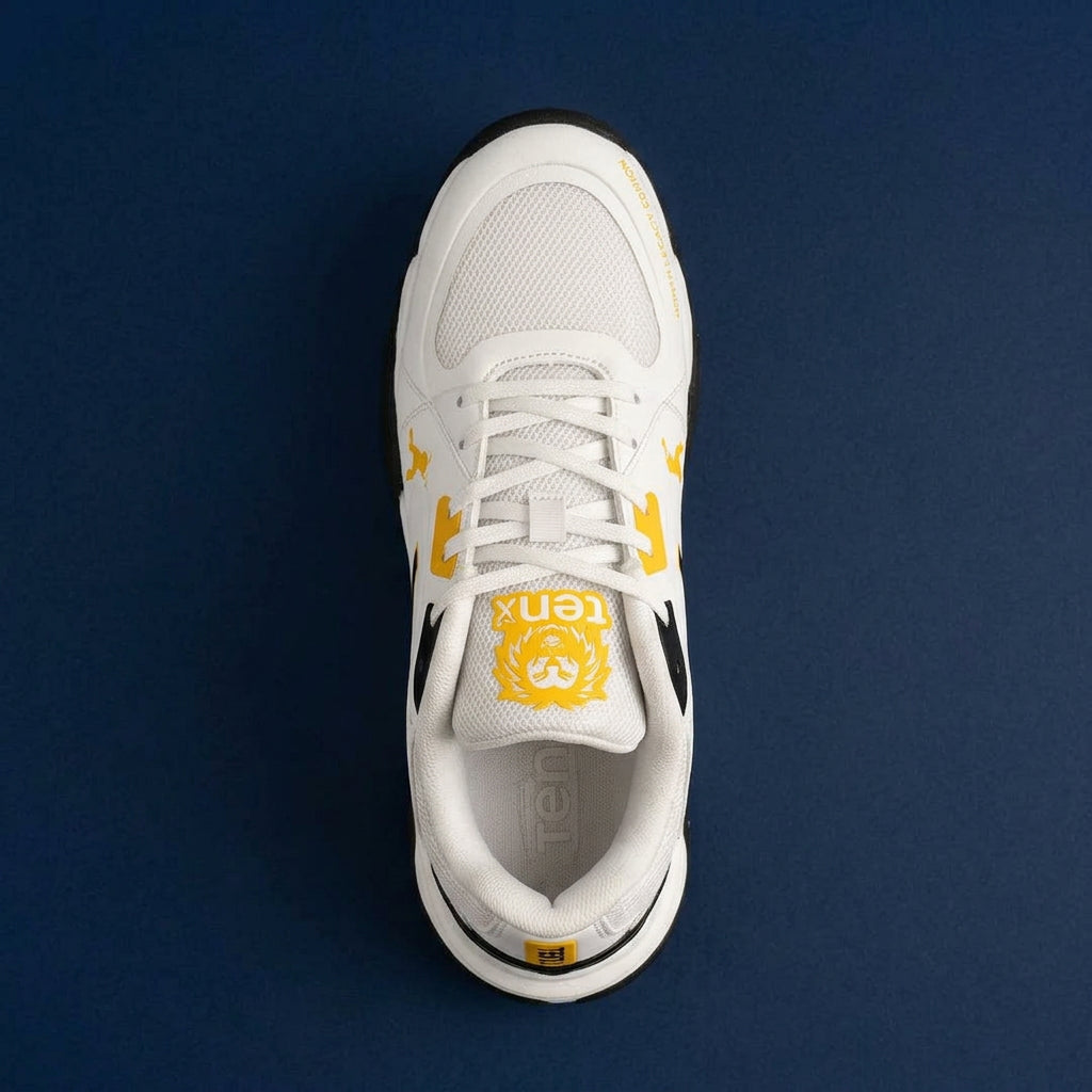 Top-down view of the Tenxu All-Rounder cricket rubber shoes in white, yellow, and black colorway, featuring a cushioned tongue with branding and a breathable mesh upper